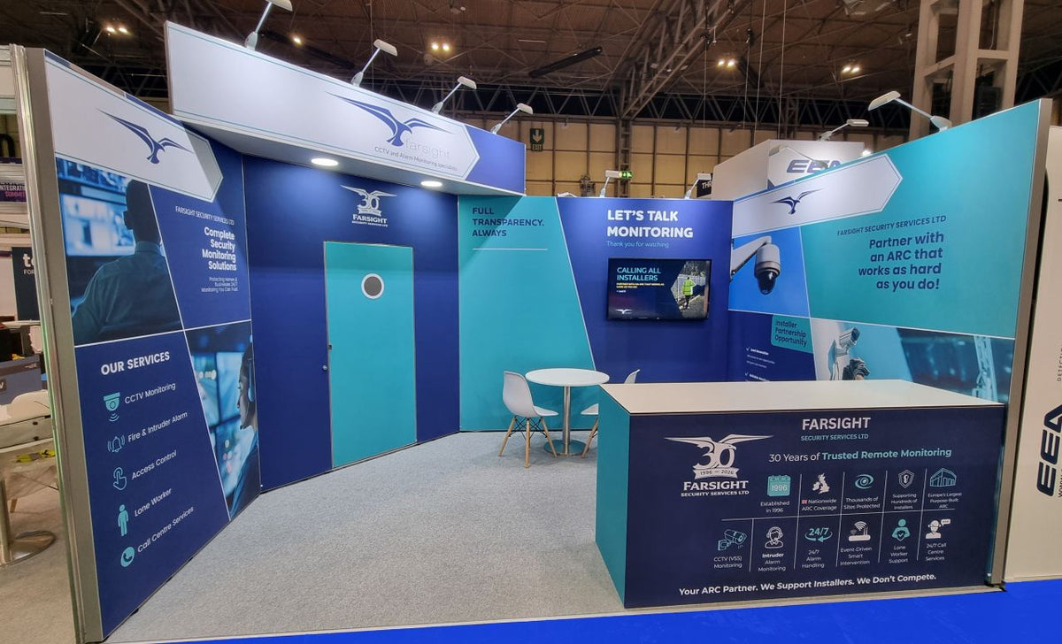 Real corner exhibition stand with 50W arm lights mounted above tall graphic panels.